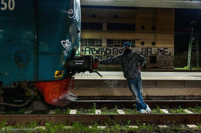 KIOK si riposa dopo aver dipinto un treno fermo alla Stazione “Roma Ostiense”, 2012